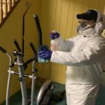 A Twin Forks staff member spraying down a home with disinfectant spray.