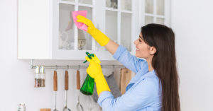 Woman cleaning kitchen cabinets