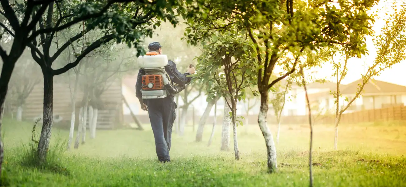 A Twin Forks Pest Control technician sprays for mosquitoes in a New York orchard