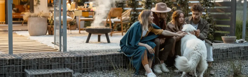 Young friends petting a white dog in the backyard. Contact Twin Forks Pest Control® for your outdoor pest control needs.
