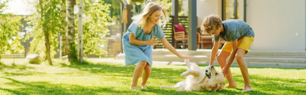 Kids in Long Island petting their dog in the backyard after having a mosquito repellent system installed