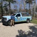 A Twin Forks Pest Control® technician stands in front of a service truck